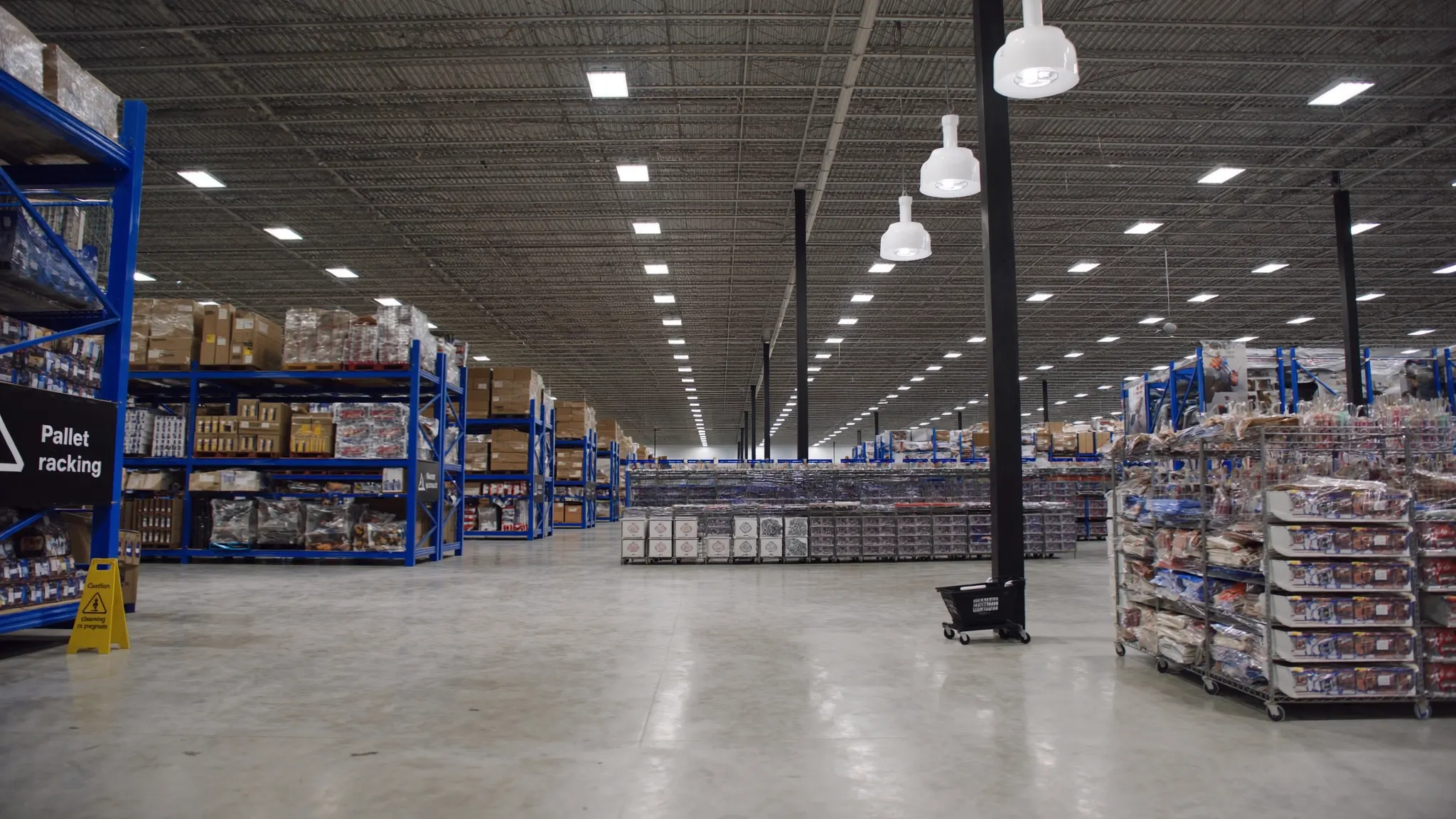 Almacén de distribución tipo mayorista con racks cargados de productos